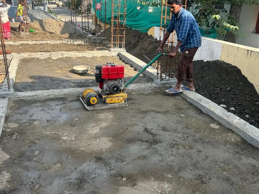 Plate compactor consolidating fill before slab construction