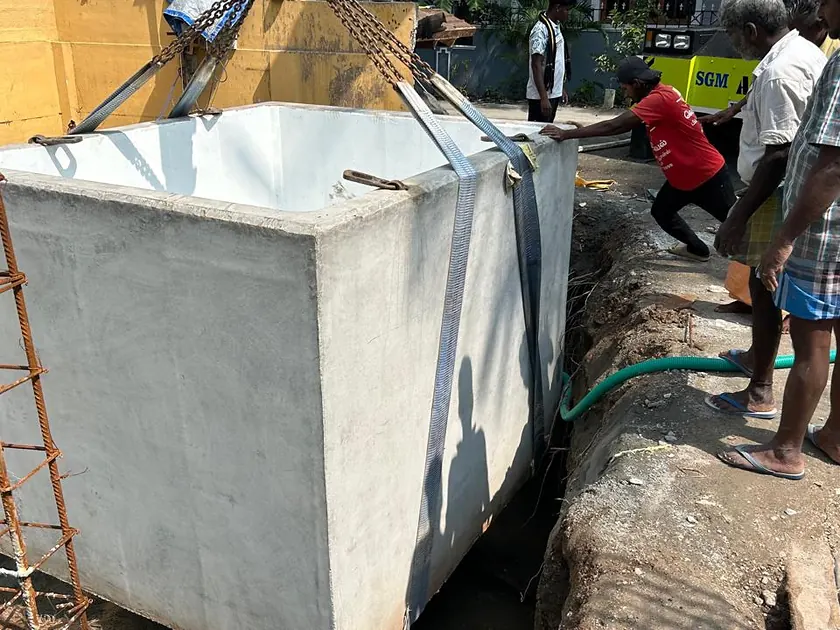Precast concrete sump being lowered into position by crane