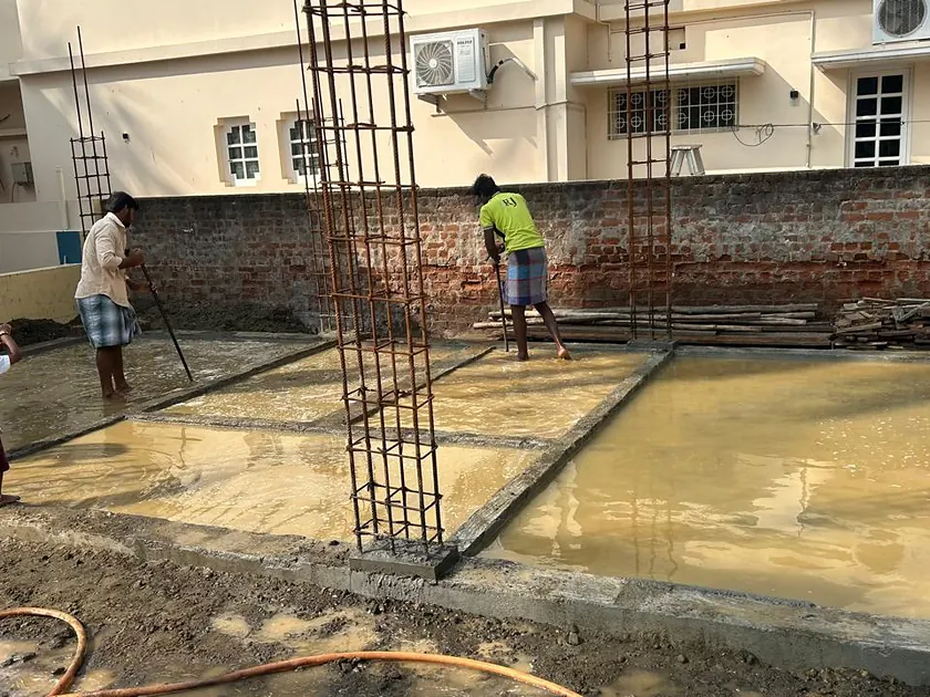 Ground slab under water curing with column reinforcement in place