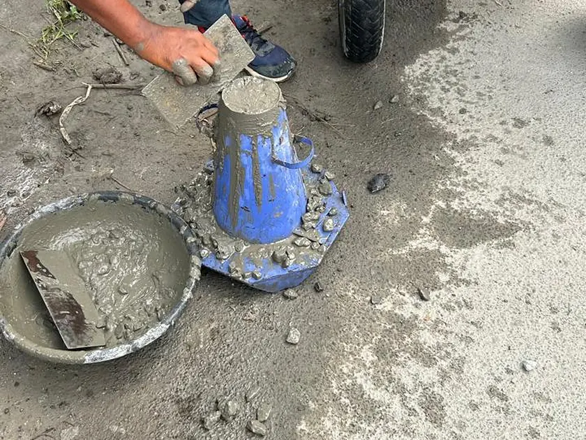 Slump cone test being carried out on fresh concrete before placing