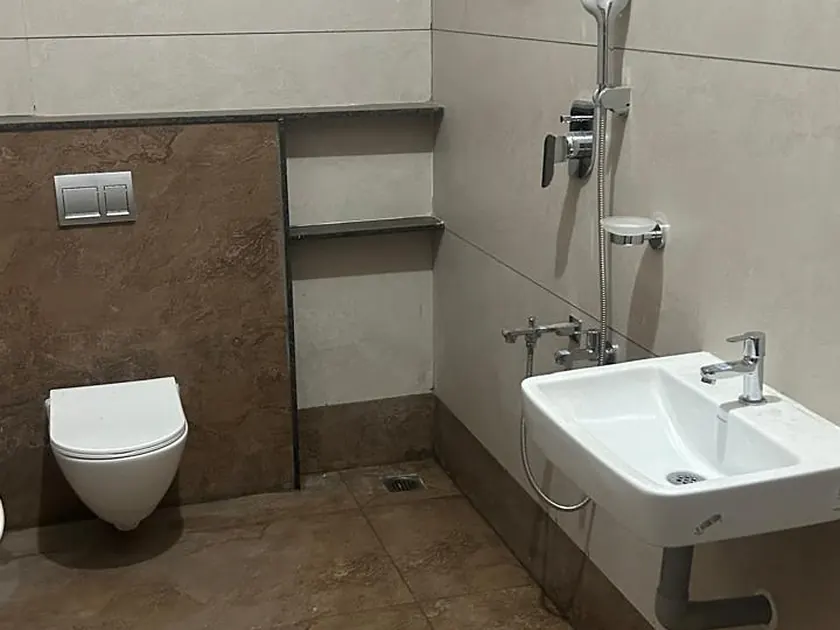 Finished bathroom with wall-hung WC, basin and full-height tiling