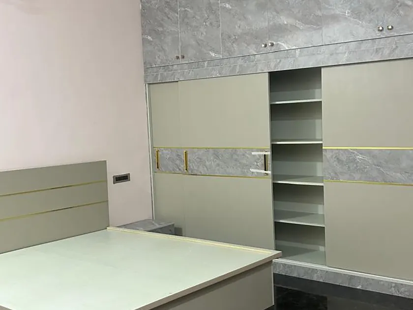 Bedroom with platform bed and open fitted wardrobe