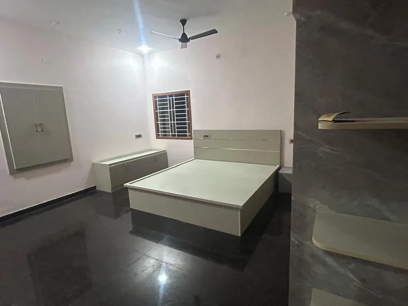 Bedroom with platform bed, wall panelling and polished dark floor