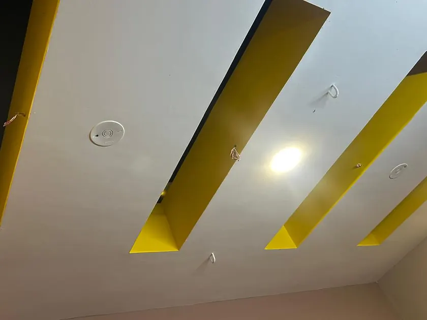 False ceiling with angled slots and concealed warm lighting