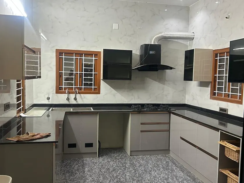 L-shaped modular kitchen with granite worktop, extractor hood and fitted cabinets