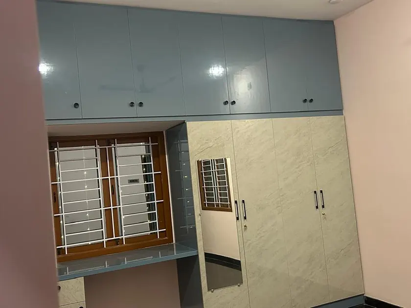 Bedroom with full-height fitted wardrobe beside a shuttered window