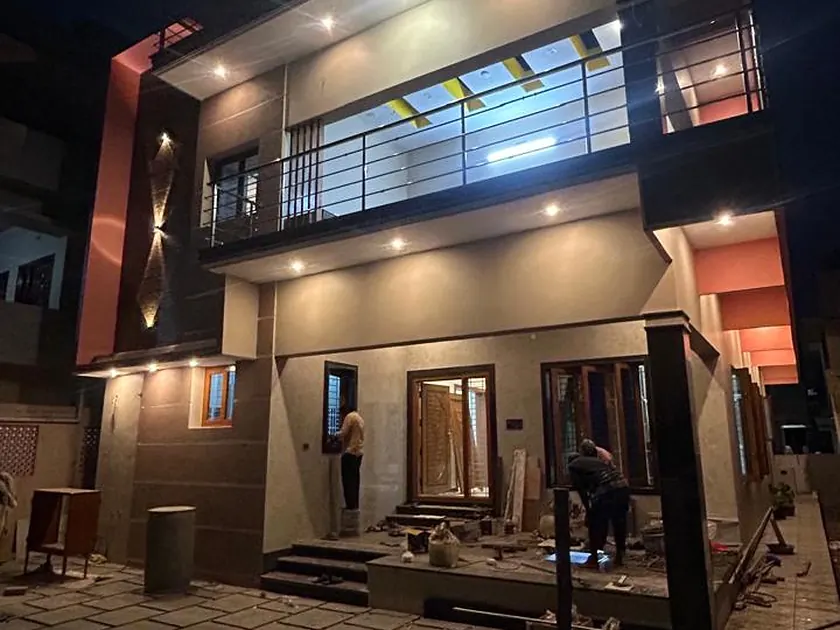 Completed two-storey residence lit at night, front elevation with balcony